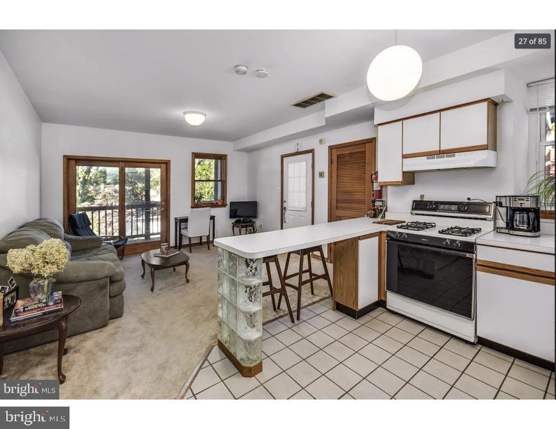 7928 Ridge Avenue Philadelphia, PA 19128 - Photo 13 of 38 a open kitchen with stainless steel appliances granite countertop a stove a sink dishwasher a dining table and chairs with wooden floor