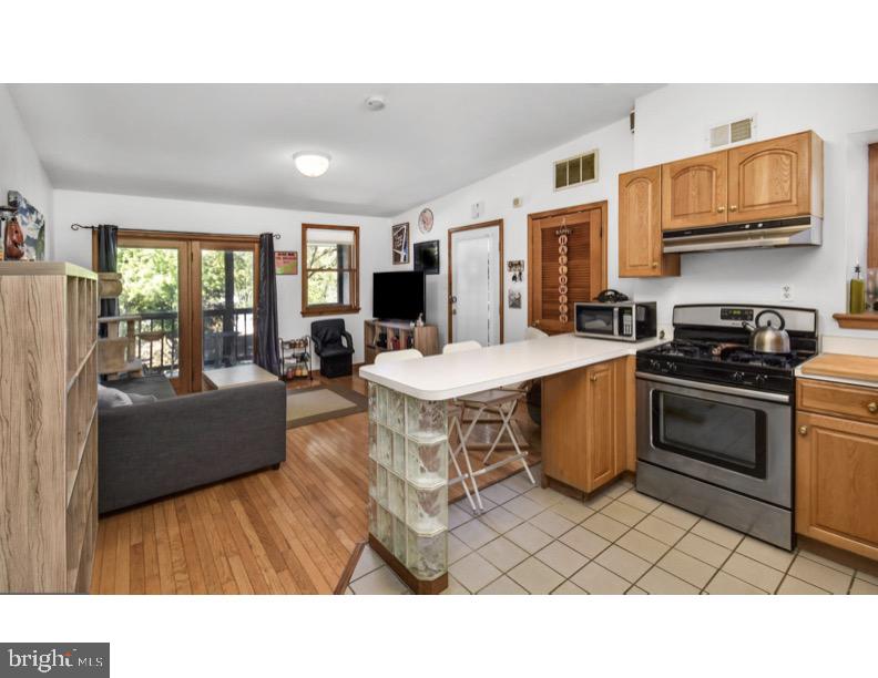 7928 Ridge Avenue Philadelphia, PA 19128 - Photo 24 of 38 a living room with stainless steel appliances kitchen island granite countertop a stove a sink dishwasher and a microwave oven with cabinets