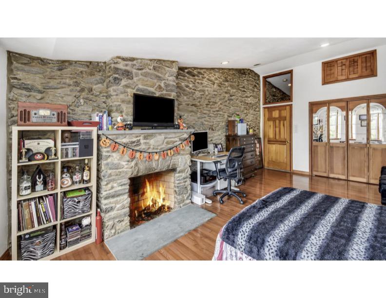 7928 Ridge Avenue Philadelphia, PA 19128 - Photo 27 of 38 a living room with furniture flat screen tv and a fireplace