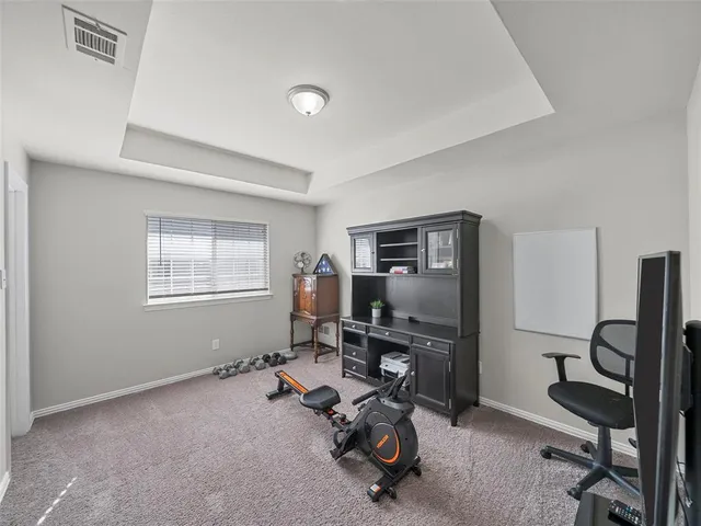 a view of a workspace with furniture and a window