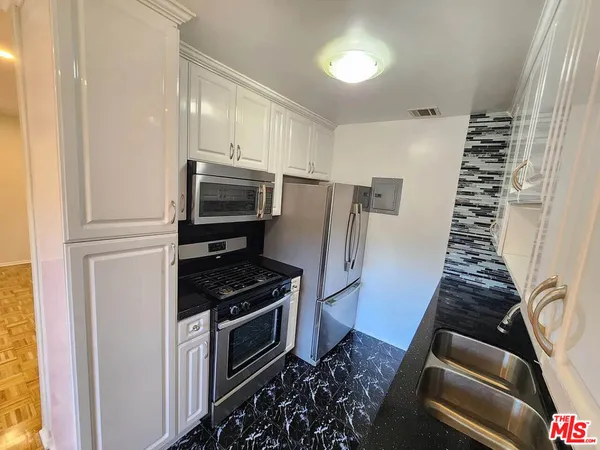a kitchen with granite countertop a stove and a refrigerator