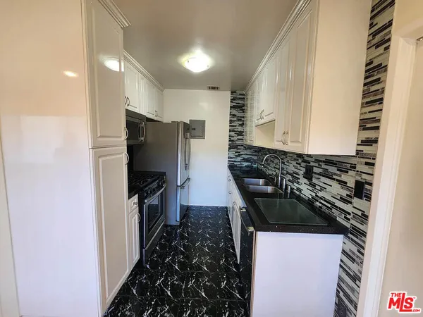 a kitchen with granite countertop a stove and a refrigerator