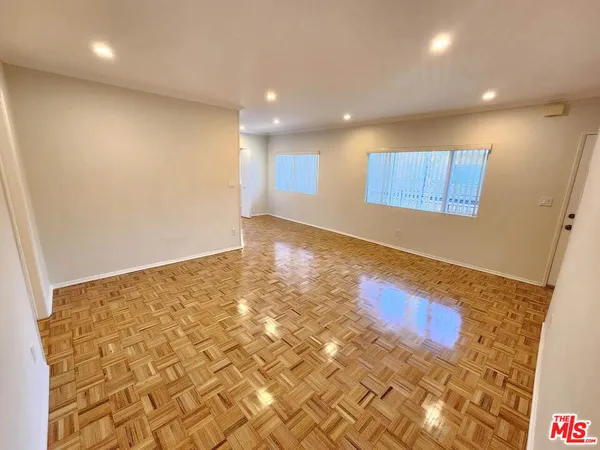 an empty room with wooden floor and bathroom