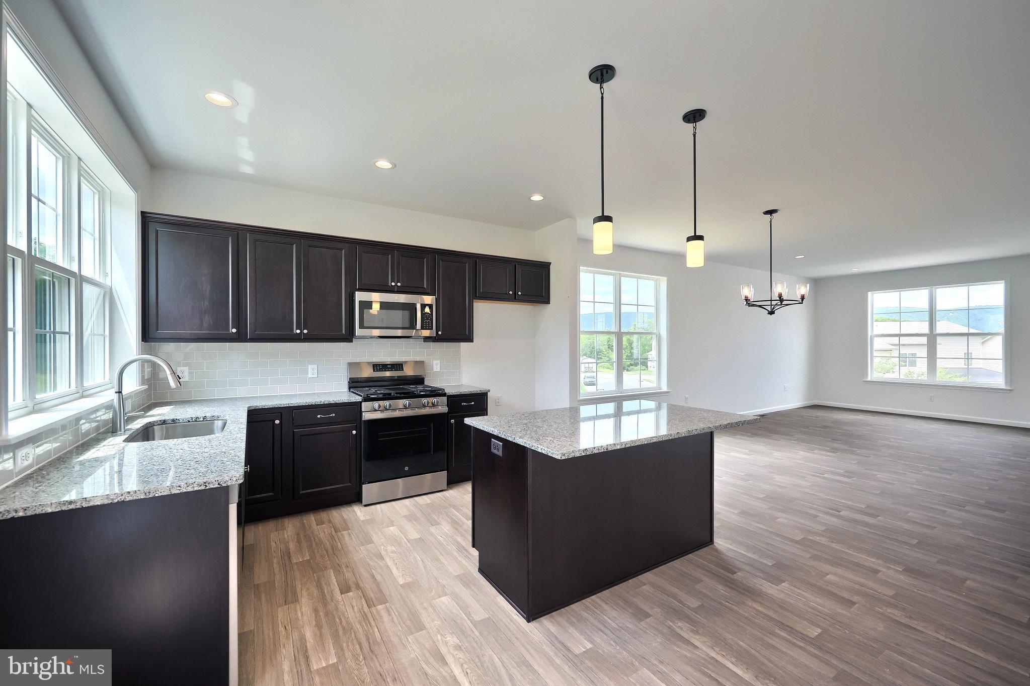 63 Glenn View Carlisle, PA 17013 - Photo 6 of 20 a kitchen with granite countertop a stove top oven a sink dishwasher a refrigerator and a dining table with wooden floor