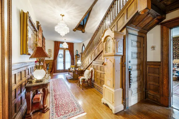 a view of a hallway with furniture and a chandelier