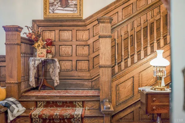 a view of staircase with lots of frames on wall and wooden floor