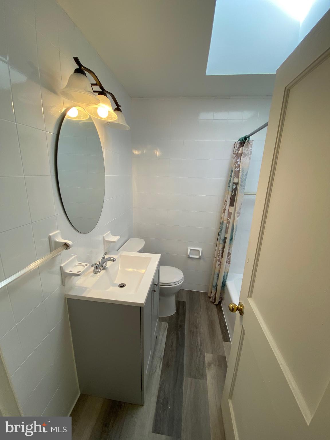 338 Gusryan Street Baltimore, MD 21224 - Photo 12 of 20 a bathroom with a sink mirror vanity and toilet
