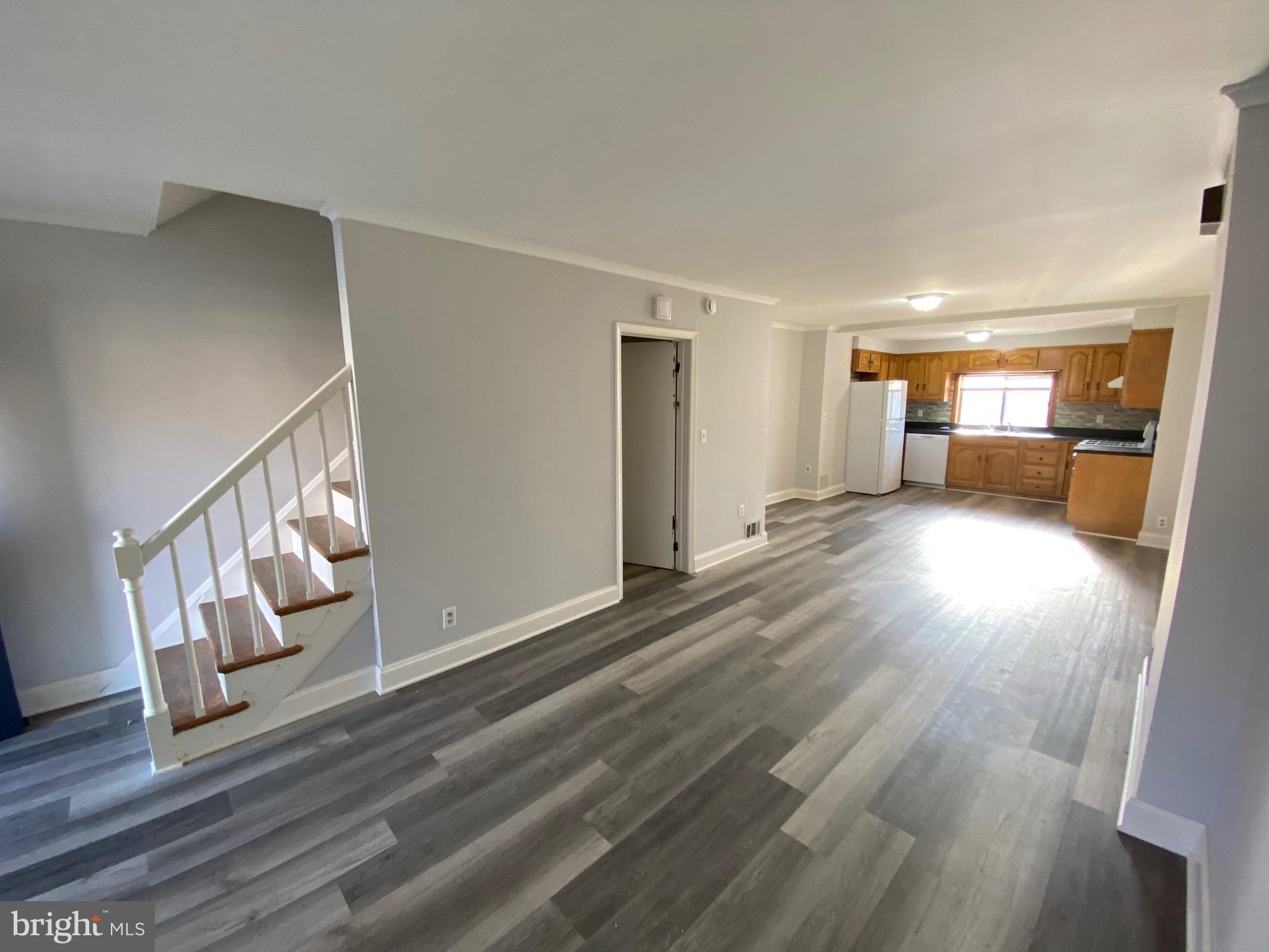 338 Gusryan Street Baltimore, MD 21224 - Photo 4 of 20 a view of an empty room with wooden floor and a window