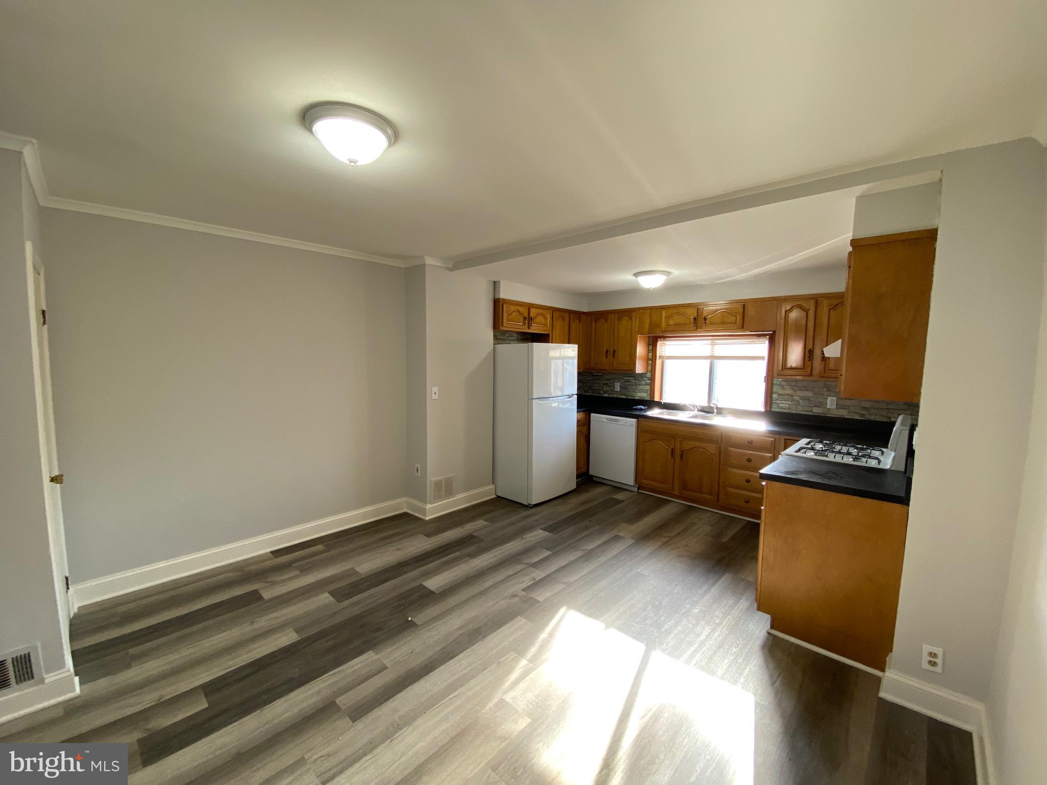 338 Gusryan Street Baltimore, MD 21224 - Photo 6 of 20 a view of kitchen with refrigerator and wooden floor