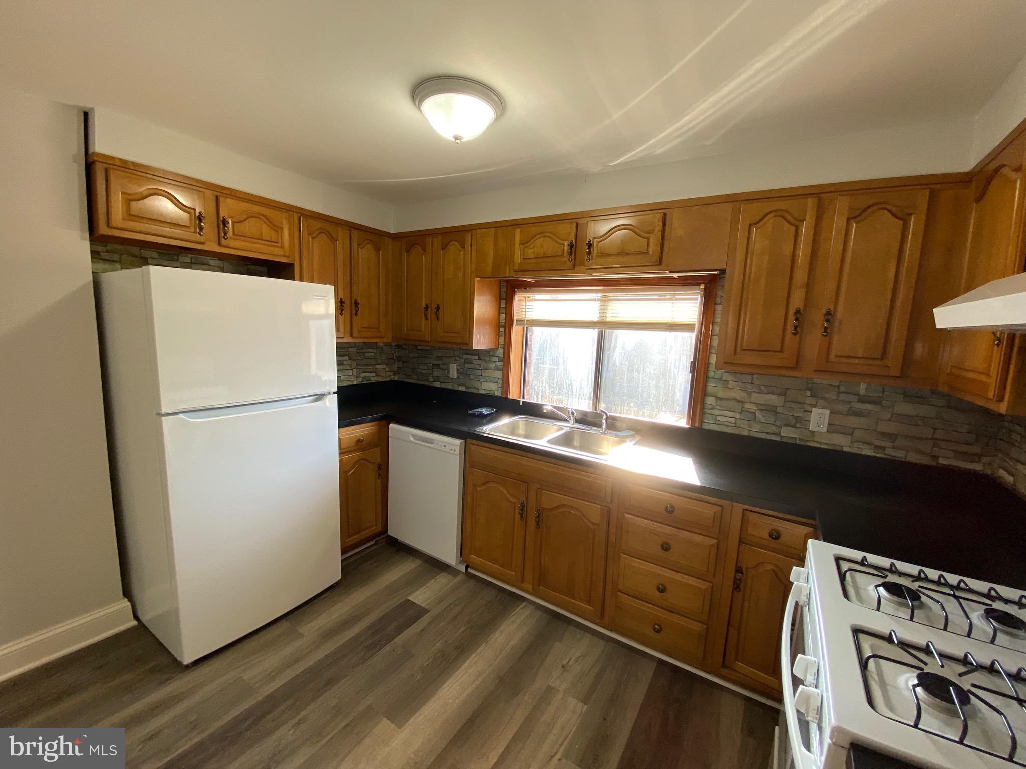 338 Gusryan Street Baltimore, MD 21224 - Photo 8 of 20 a kitchen with granite countertop stainless steel appliances a refrigerator a sink and cabinets
