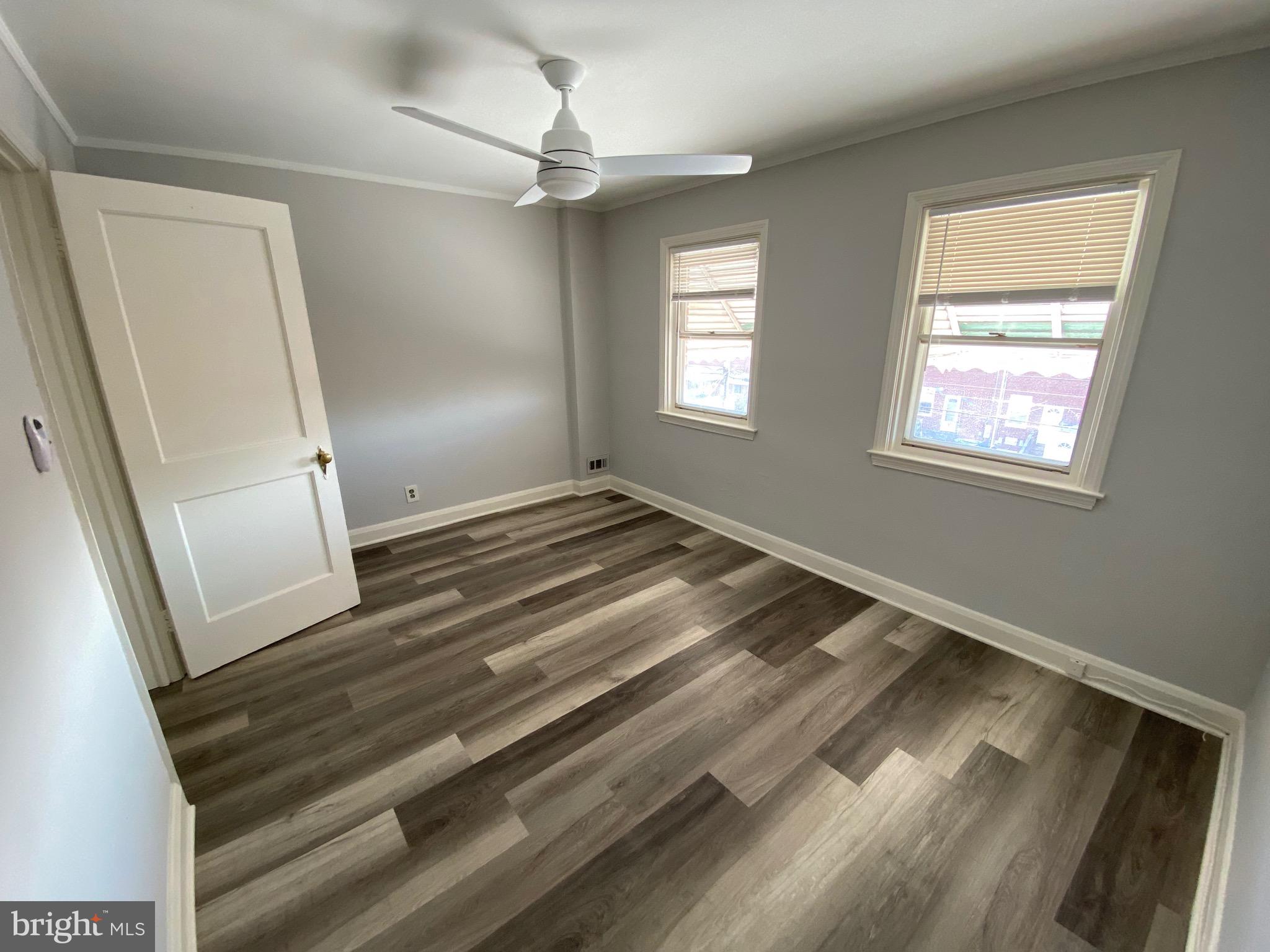 338 Gusryan Street Baltimore, MD 21224 - Photo 10 of 20 a view of an empty room with wooden floor and a window