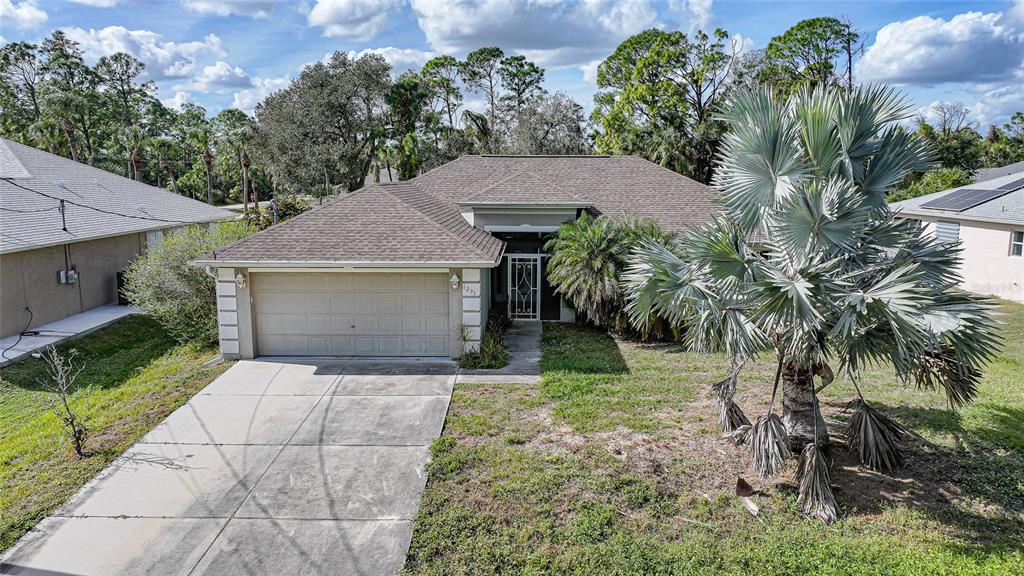 1291 Impala Street North Port, FL 34288 - Photo 1 of 44 a front view of a house with a yard and garage