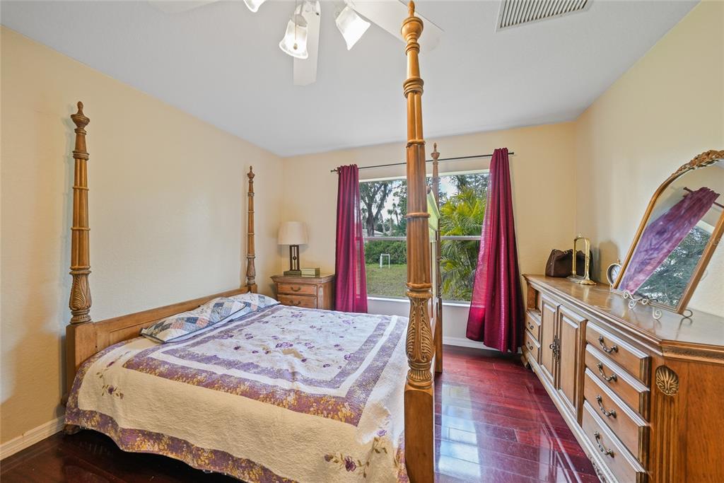 1291 Impala Street North Port, FL 34288 - Photo 18 of 44 a bedroom with a bed a flat screen tv and a large mirror on the dresser