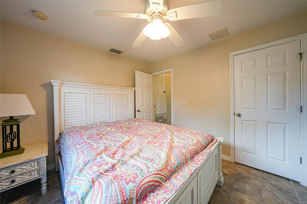 1291 Impala Street North Port, FL 34288 - Photo 24 of 44 a bedroom with a bed and a chandelier