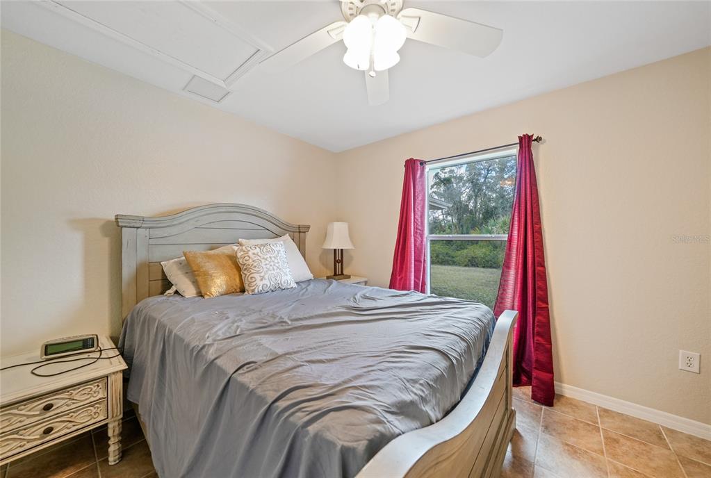 1291 Impala Street North Port, FL 34288 - Photo 28 of 44 a bedroom with a bed and a chandelier