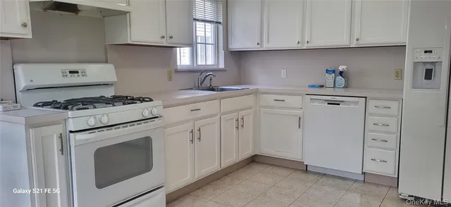 a kitchen with white cabinets and white appliances