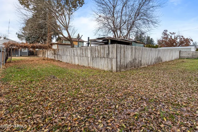 a view of backyard with wooden fence