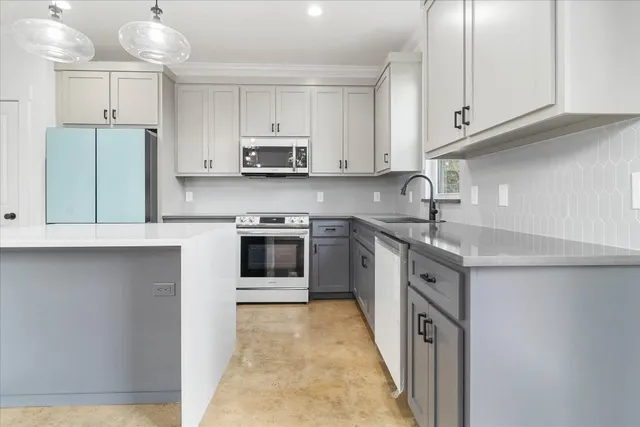 a kitchen with stainless steel appliances granite countertop a sink a stove a refrigerator and cabinets