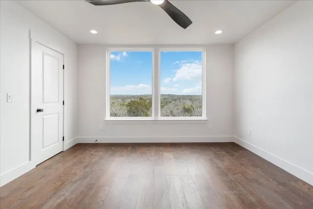 an empty room with wooden floor and windows