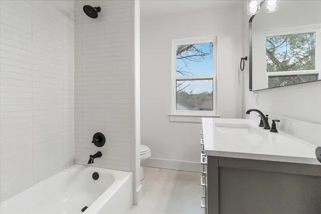 a bathroom with a tub sink and mirror