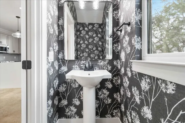 a bathroom with a sink and mirror with bathtub