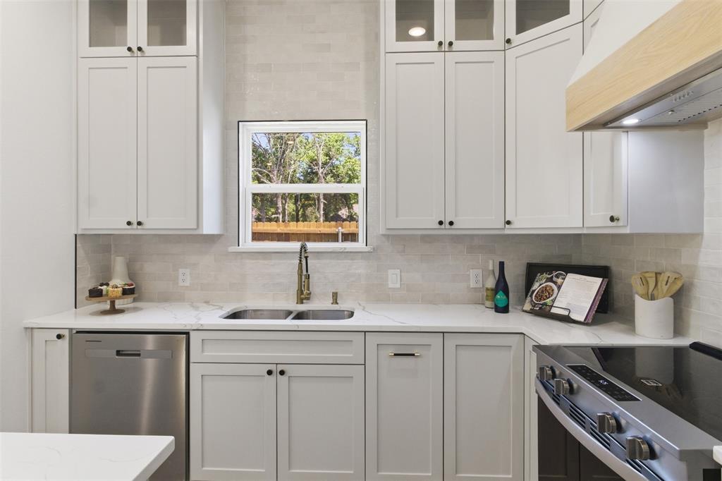 435 Waterboard Road Trinidad, TX 75163 - Photo 9 of 39 Modern kitchen featuring white shaker cabinetry, stainless steel appliances, a double basin sink with an arched faucet, light-toned tile backsplash, and light-colored countertops