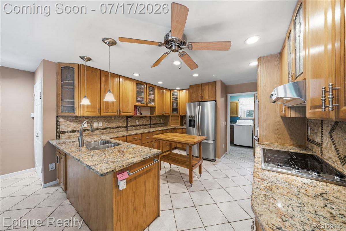 22520 Waltz Road New Boston, MI 48164 - Photo 20 of 43 Open kitchen featuring granite countertops, wood cabinetry, stainless steel appliances, tile flooring, and recessed lighting
