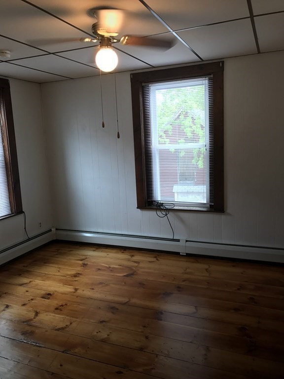 100 4th Avenue Lowell, MA 01854 - Photo 5 of 12 a view of an empty room with wooden floor and a window