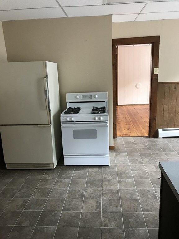 100 4th Avenue Lowell, MA 01854 - Photo 7 of 12 a kitchen with a stove top oven cabinets and a refrigerator
