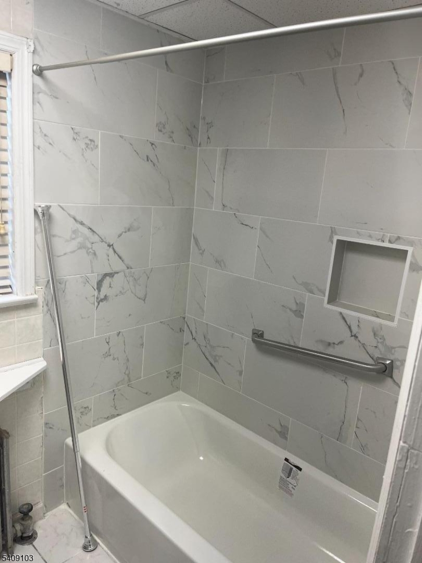 136 East Main Street, Unit 1 Little Falls, NJ 07424 - Photo 6 of 11 a bath tub sitting next to a white sink and vanity