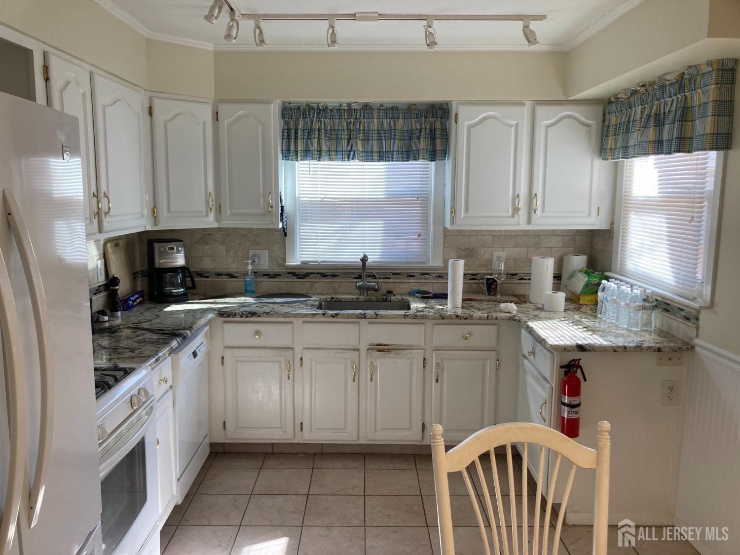 60 Edwards Road Brick, NJ 08723 - Photo 5 of 49 a kitchen with granite countertop white cabinets white appliances a sink and a window