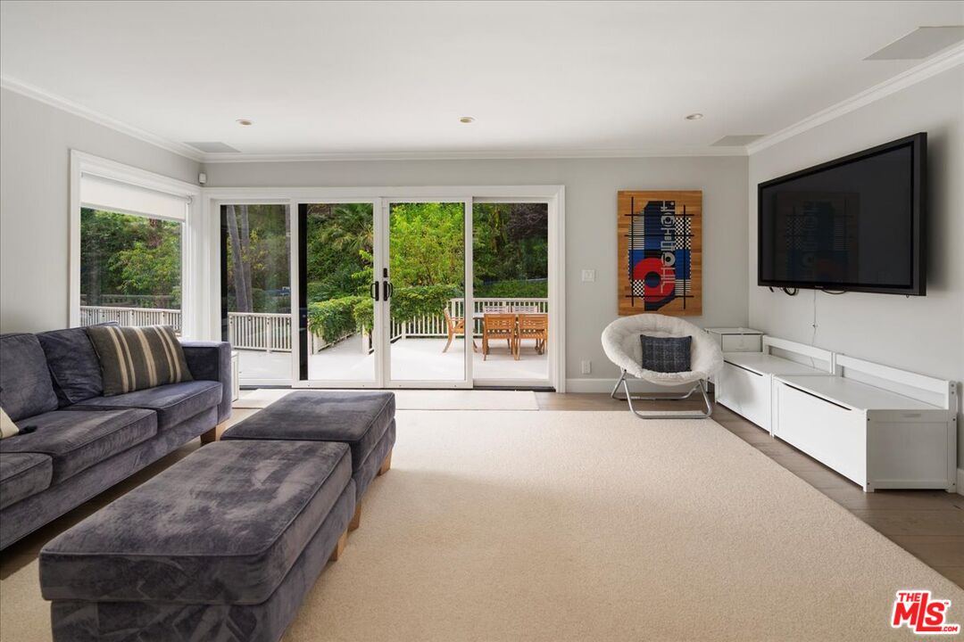 3479 Mandeville Canyon Road Los Angeles, CA 90049 - Photo 11 of 55 a living room with furniture and a flat screen tv