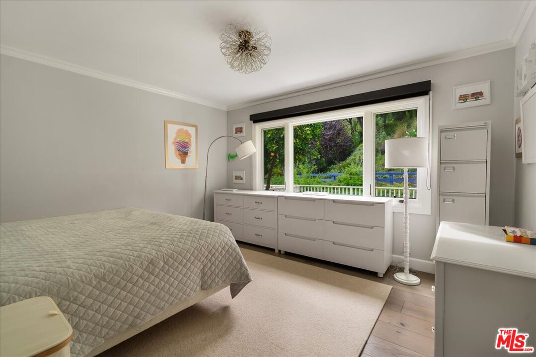 3479 Mandeville Canyon Road Los Angeles, CA 90049 - Photo 16 of 55 a bedroom with a bed and a large window