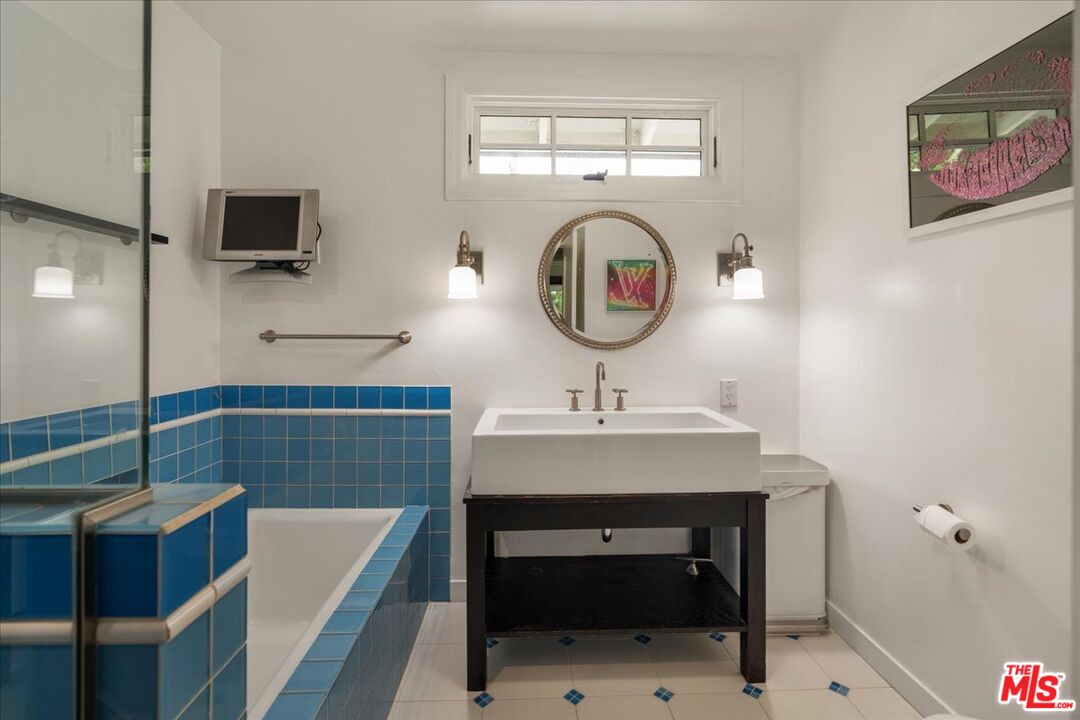 3479 Mandeville Canyon Road Los Angeles, CA 90049 - Photo 19 of 55 a bathroom with a sink a toilet and a mirror