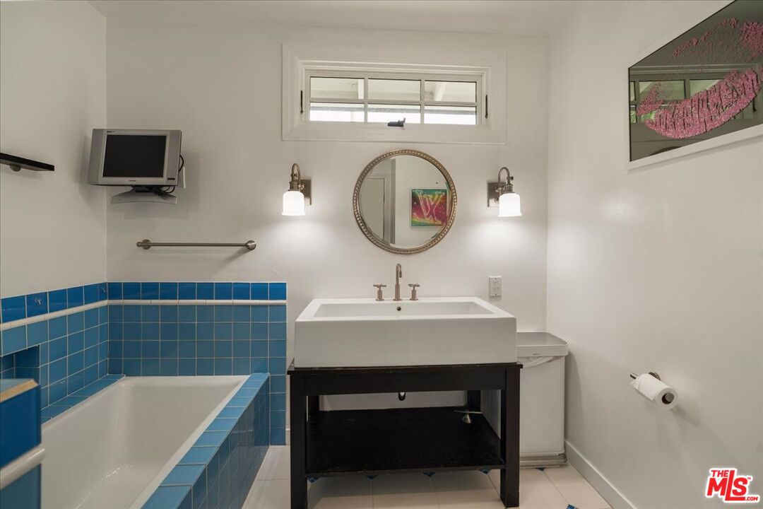 3479 Mandeville Canyon Road Los Angeles, CA 90049 - Photo 20 of 55 a bathroom with a sink a bathtub and a mirror