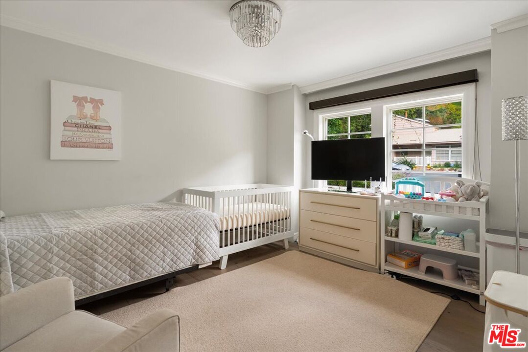 3479 Mandeville Canyon Road Los Angeles, CA 90049 - Photo 21 of 55 a room with a bed furniture and a flat screen tv