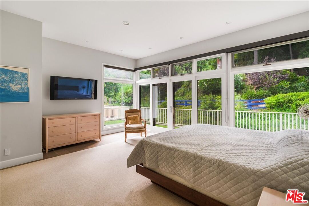 3479 Mandeville Canyon Road Los Angeles, CA 90049 - Photo 25 of 55 a bedroom with a bed and large window