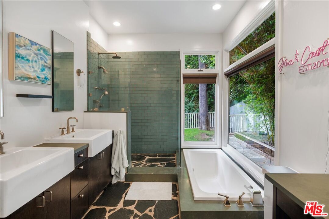 3479 Mandeville Canyon Road Los Angeles, CA 90049 - Photo 27 of 55 a bathroom with a sink a large mirror and a bathtub