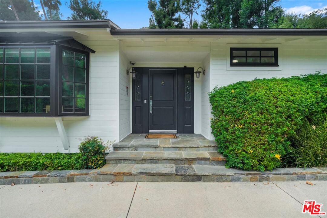 3479 Mandeville Canyon Road Los Angeles, CA 90049 - Photo 45 of 55 a front view of a house with a yard