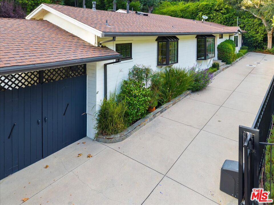 3479 Mandeville Canyon Road Los Angeles, CA 90049 - Photo 46 of 55 a front view of a house with garden