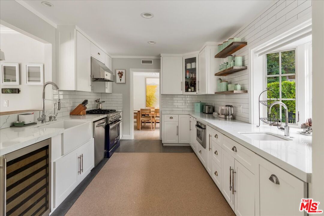 3479 Mandeville Canyon Road Los Angeles, CA 90049 - Photo 7 of 55 a kitchen with white cabinets and white appliances