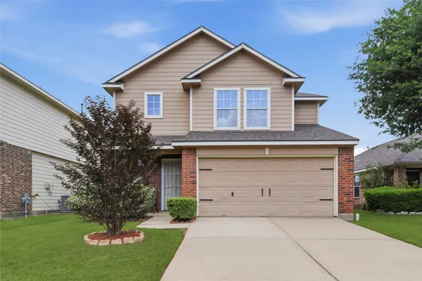 a front view of a house with a garden and garage