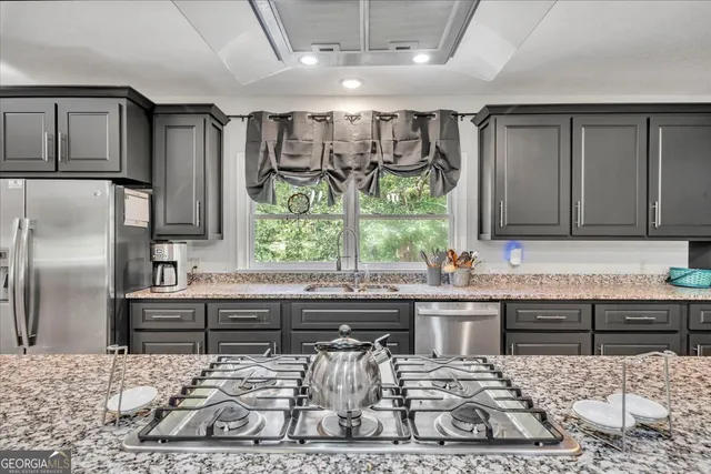 a kitchen with a stove a sink and a refrigerator