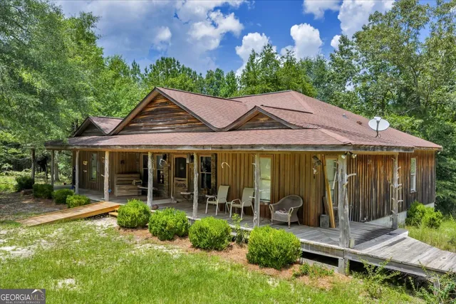an aerial view of a residential houses with outdoor space and trees