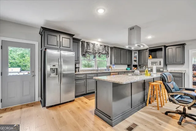 a kitchen with stainless steel appliances granite countertop a sink a stove and a refrigerator