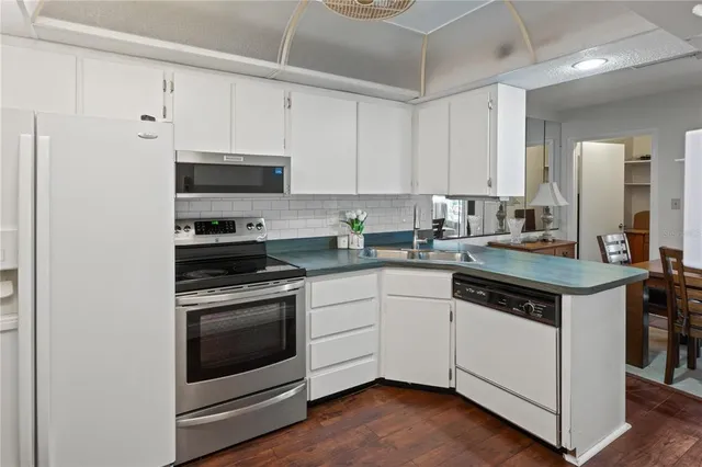 a kitchen with stainless steel appliances granite countertop a sink dishwasher and cabinets with wooden floor