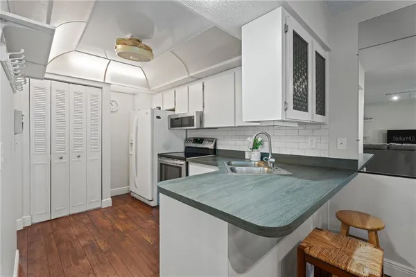 a large kitchen with kitchen island a stove a sink a dining table and chairs