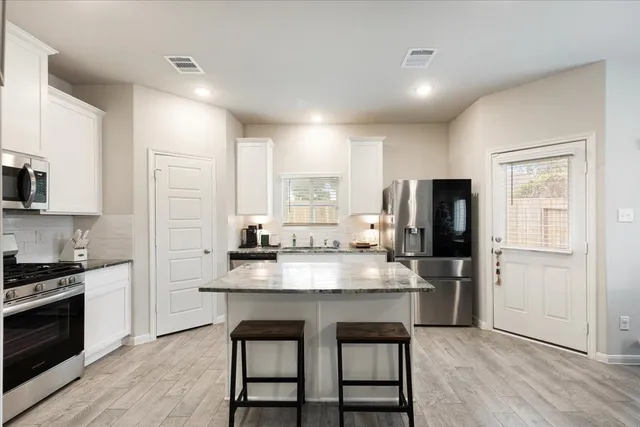 a kitchen with refrigerator and cabinets