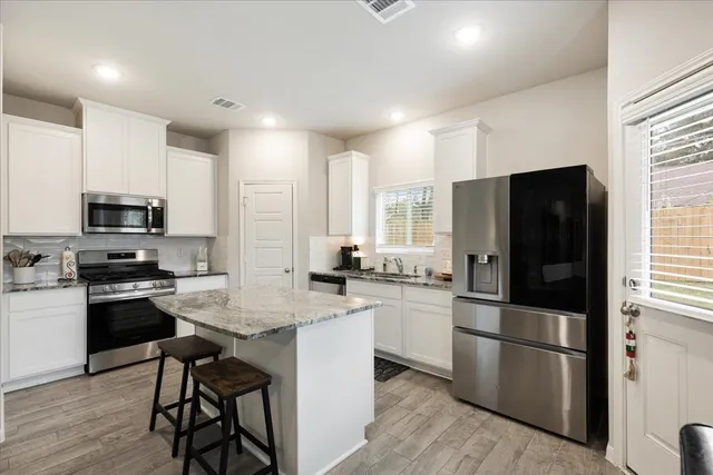 a kitchen with stainless steel appliances a refrigerator stove microwave and sink