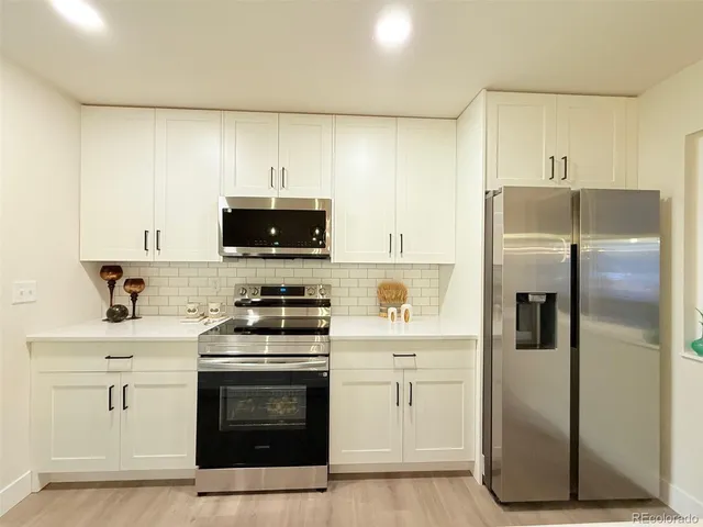 a kitchen with a refrigerator stove and microwave